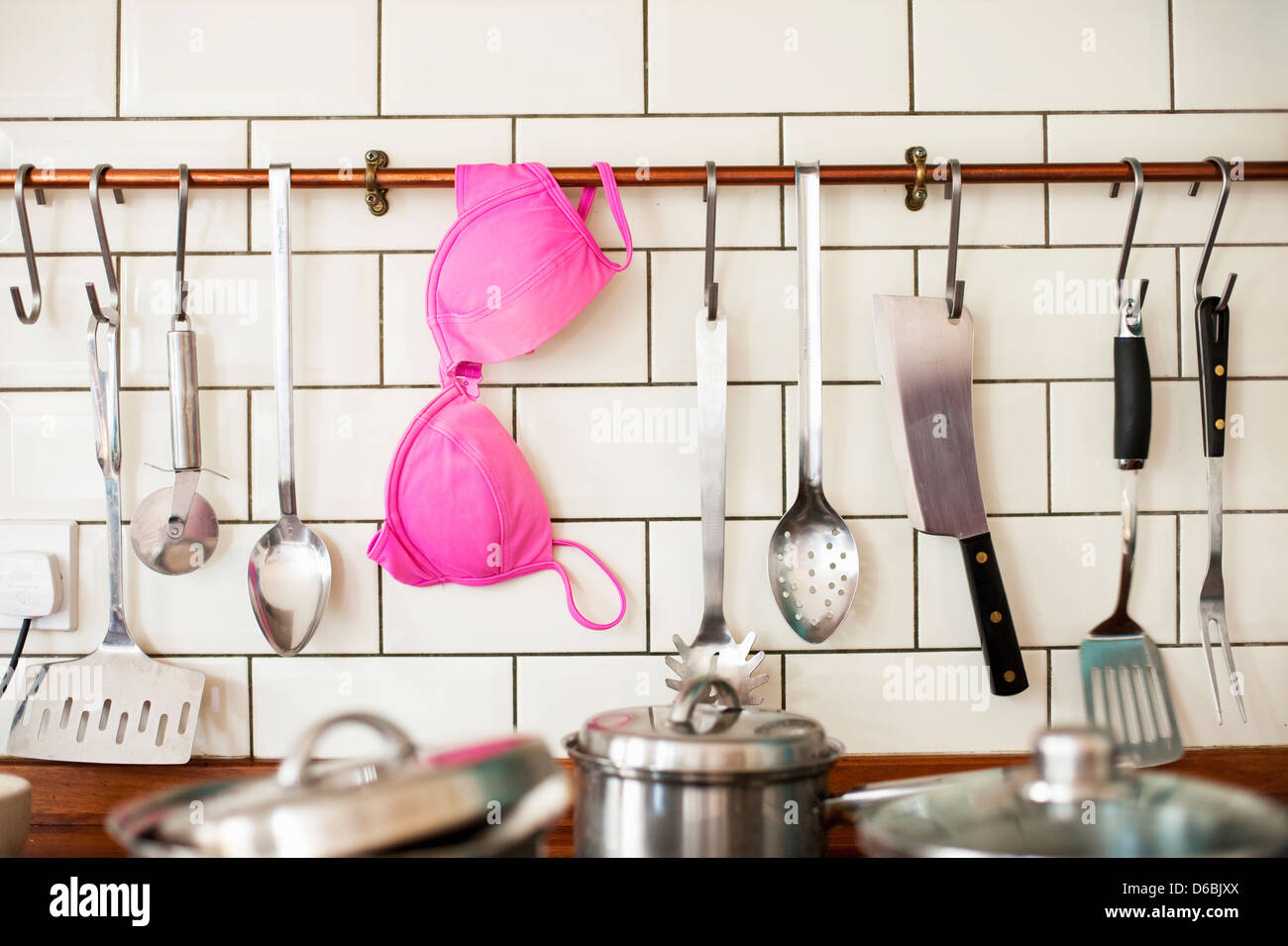 Reggiseno rosa appesi in cucina Foto Stock
