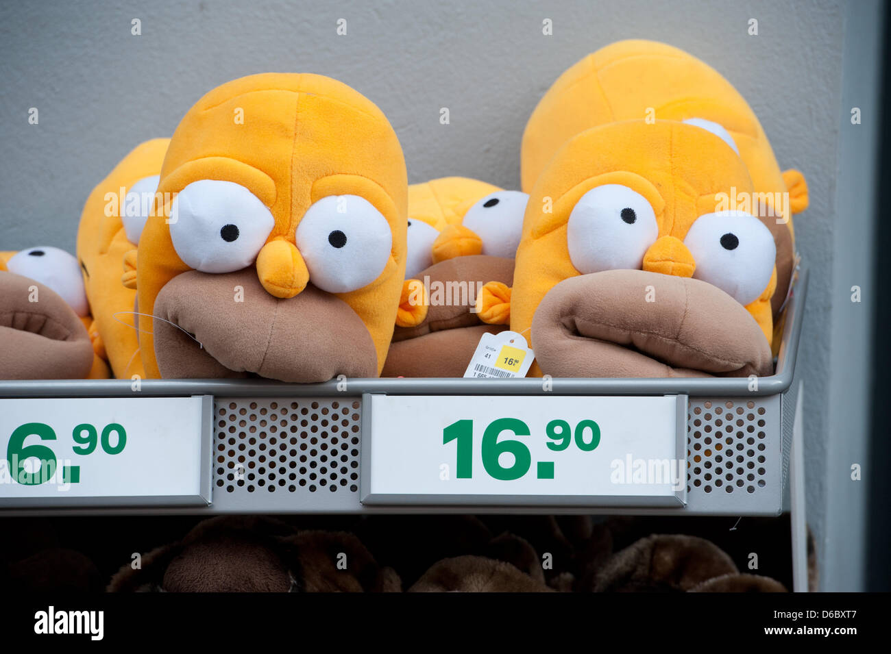Pantofole progettato come testa di fumetto di figura 'Homer Simpson' sono  in esposizione in un negozio in Stalsund, Germania, 04 gennaio 2012. Foto:  Stefan Sauer Foto stock - Alamy
