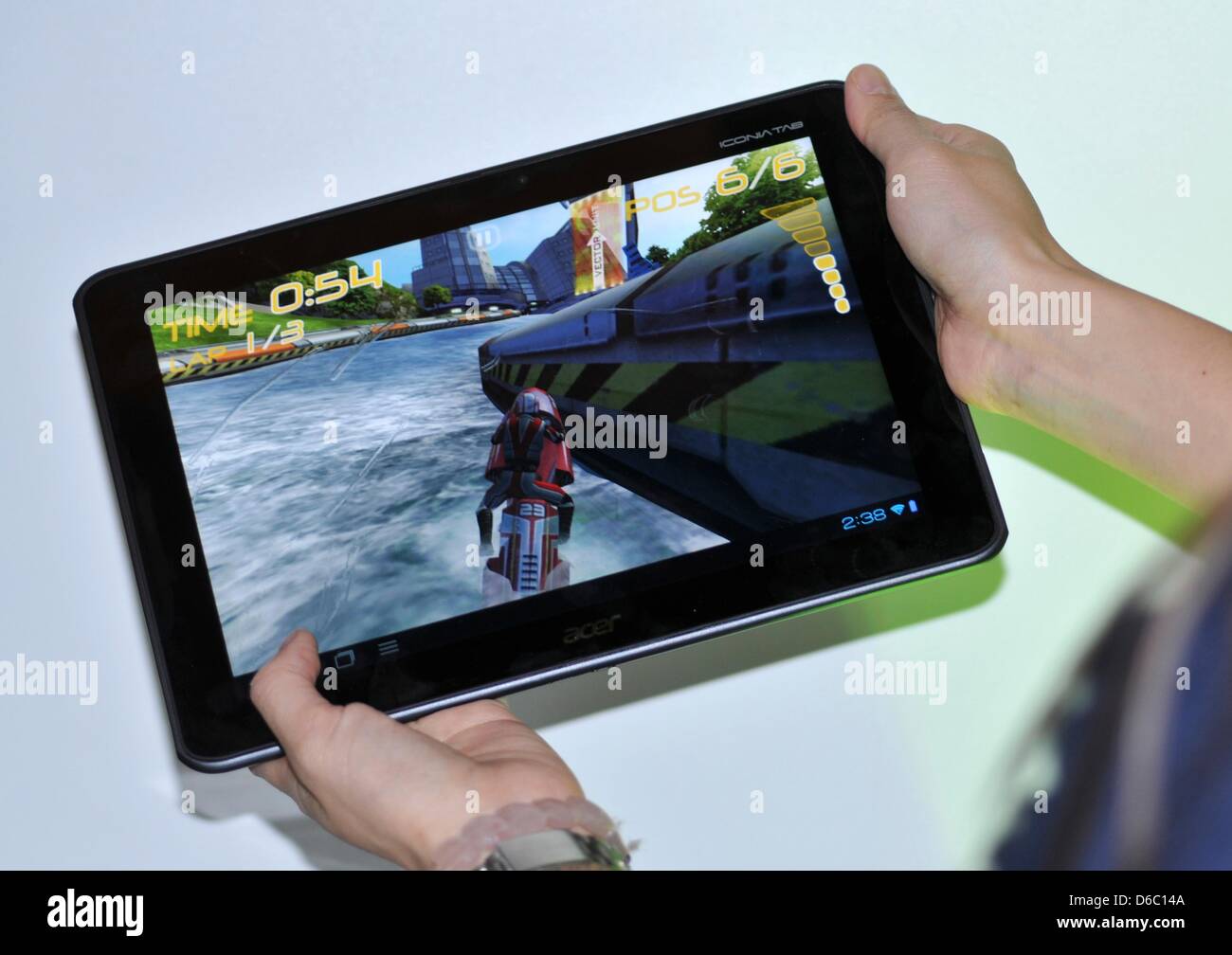 Un Acer membro dello staff presenta un nuovo tablet pc della serie Iconia dalla Taiwan azienda di computer Acer mostra una moto simulazione di corse al Consumer Electronics Show (CES) di Las Vegas, Stati Uniti d'America, 08 Jauary 2012. Il tablet PC è dotato di un processore quad core il cui aumento delle prestazioni di elaborazione potranno beneficiare i video e i giochi per computer. Il tablet è anche equi Foto Stock