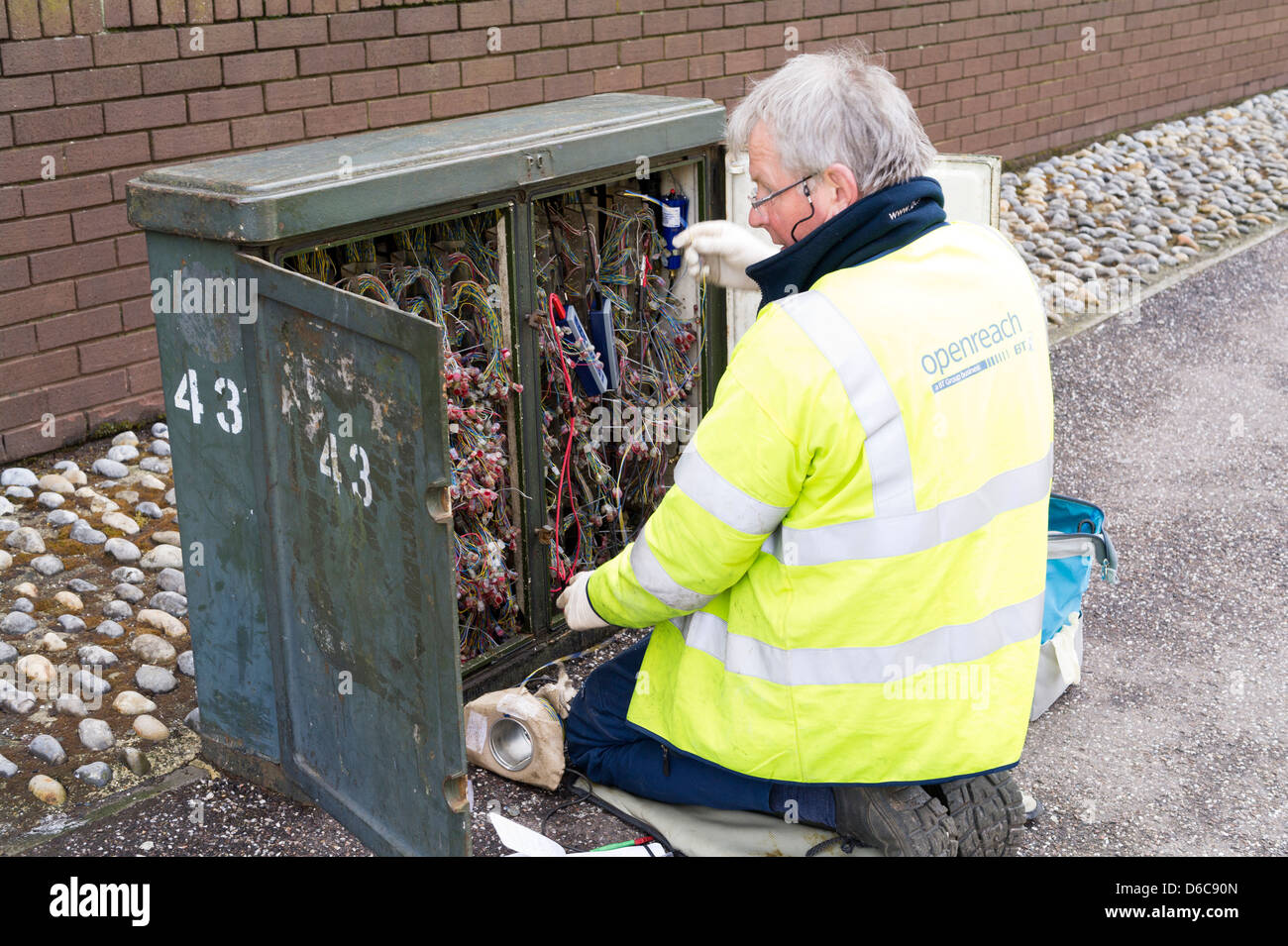 Ingegnere di telefono funzionante a street junction box. Foto Stock