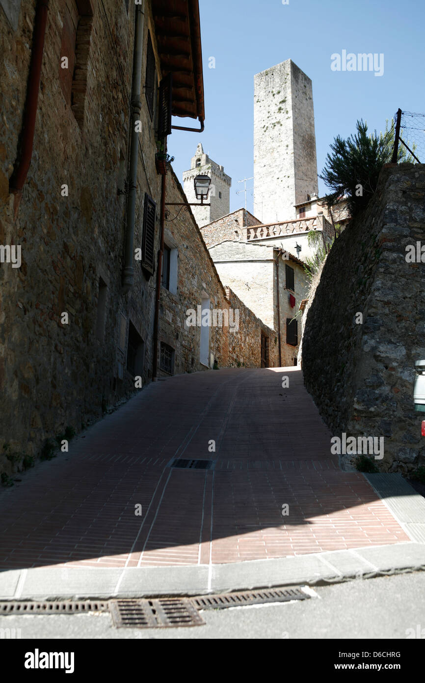 Una tranquilla stradina che conduce fino a una vecchia torre di San Gimignano Toscana Italia Foto Stock