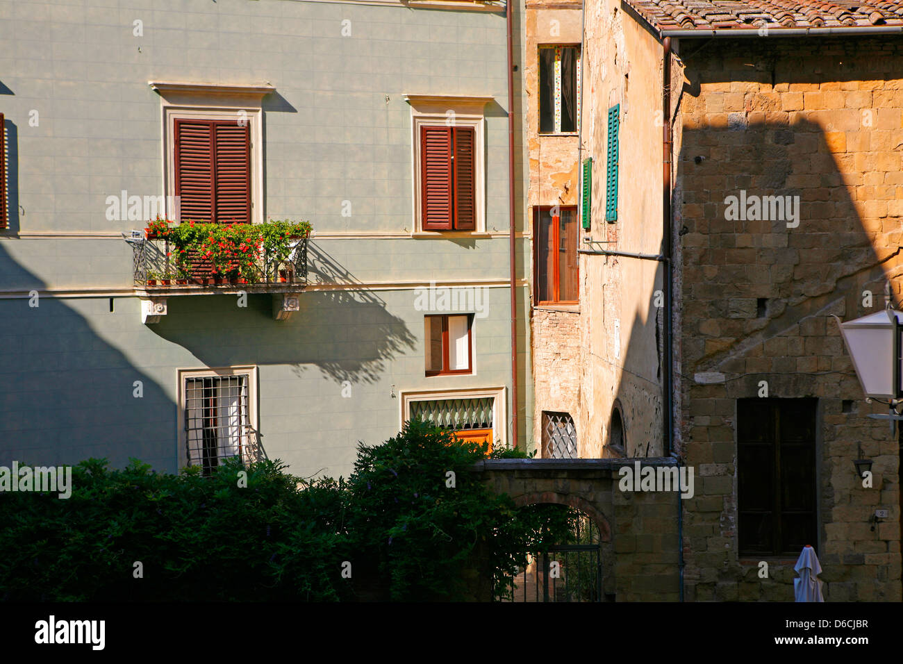 Siena case in condizioni di luce solare intensa con finestre con persiane Foto Stock