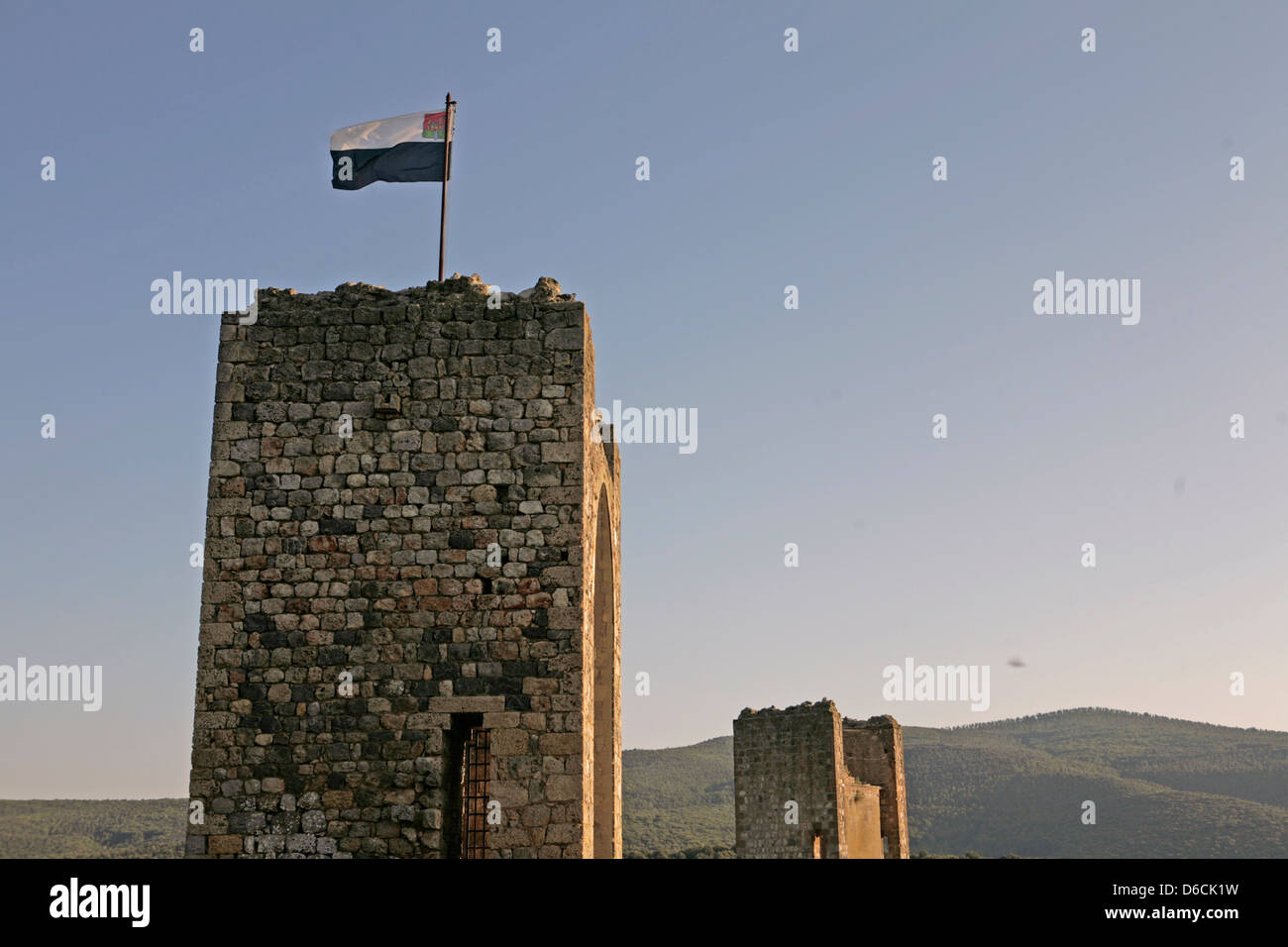 Bandiera su un rinascimento torre in pietra in Monteriggioni Toscana Italia al tramonto Foto Stock