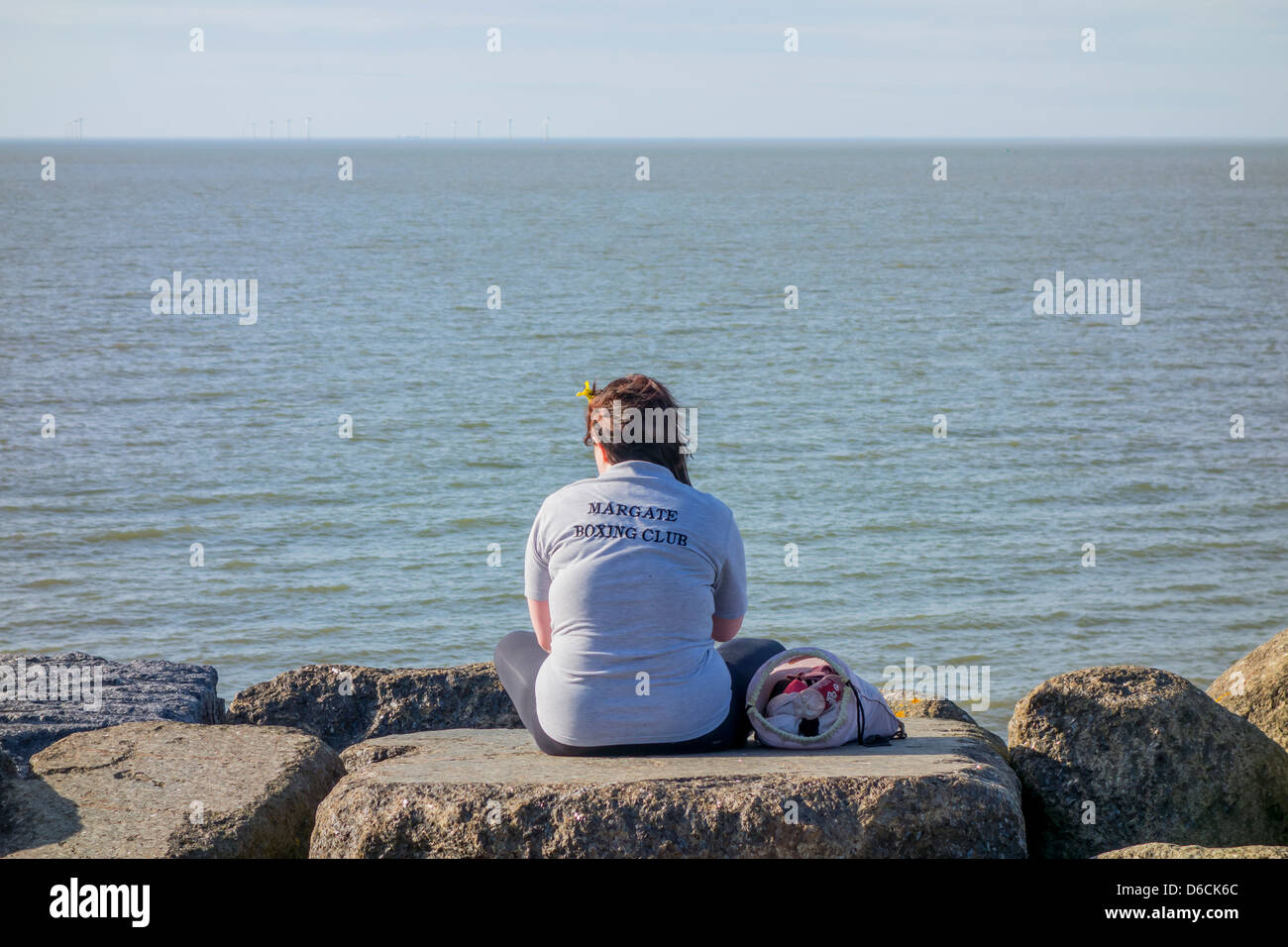 Lone ragazza seduta sulla spiaggia a Margate Boxing Club Foto Stock