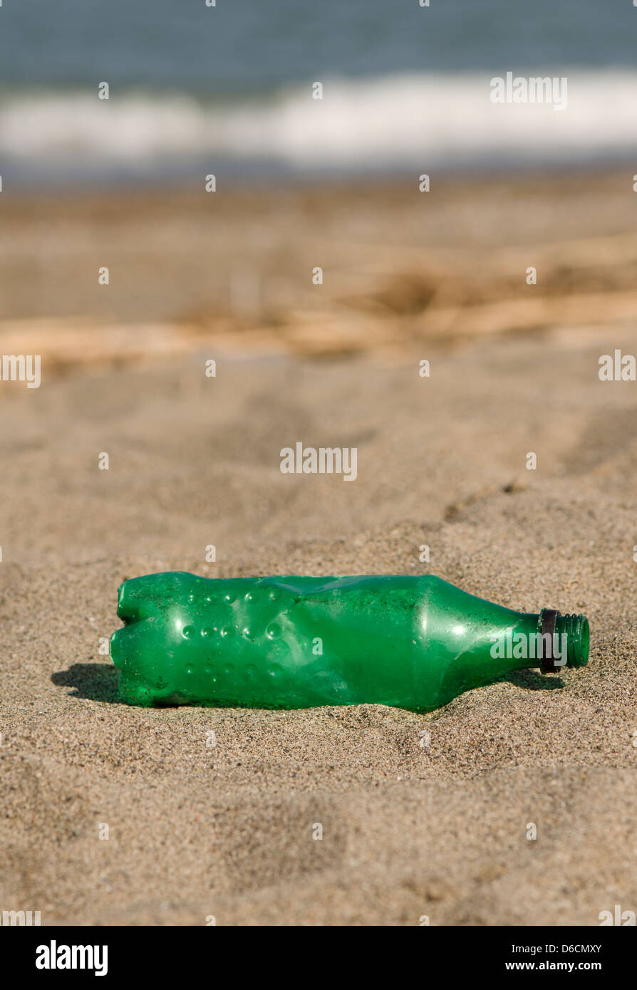 Plastica bottiglia verde sulla spiaggia Foto Stock