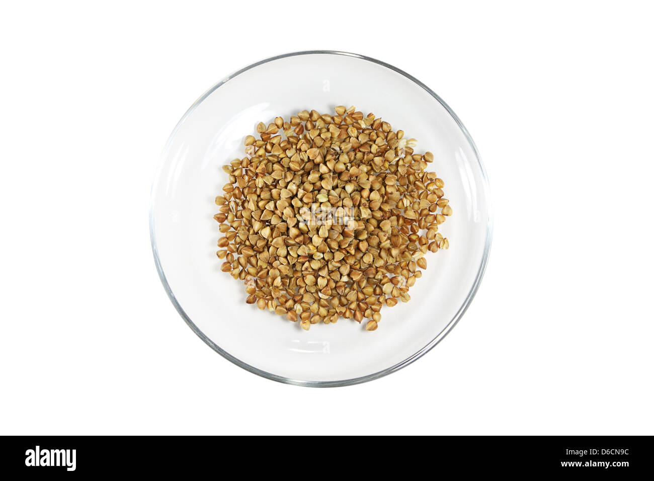 Il grano saraceno in una ciotola di vetro isolato su sfondo bianco Foto Stock