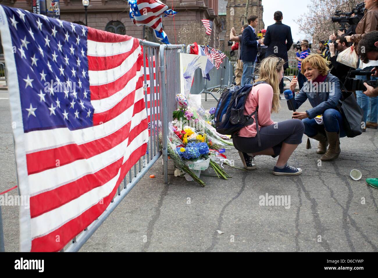 Boston, MA, Stati Uniti d'America 16 Aprile 2013 Una donna in visita presso un santuario crescente di fiori, bandiere e memorabilia di Boston ad appena un isolato di distanza dal traguardo della Maratona di Boston su Boylston Street il giorno dopo le esplosioni si è verificato. Credito: SHAUN RAMSAY/Alamy Live News Foto Stock