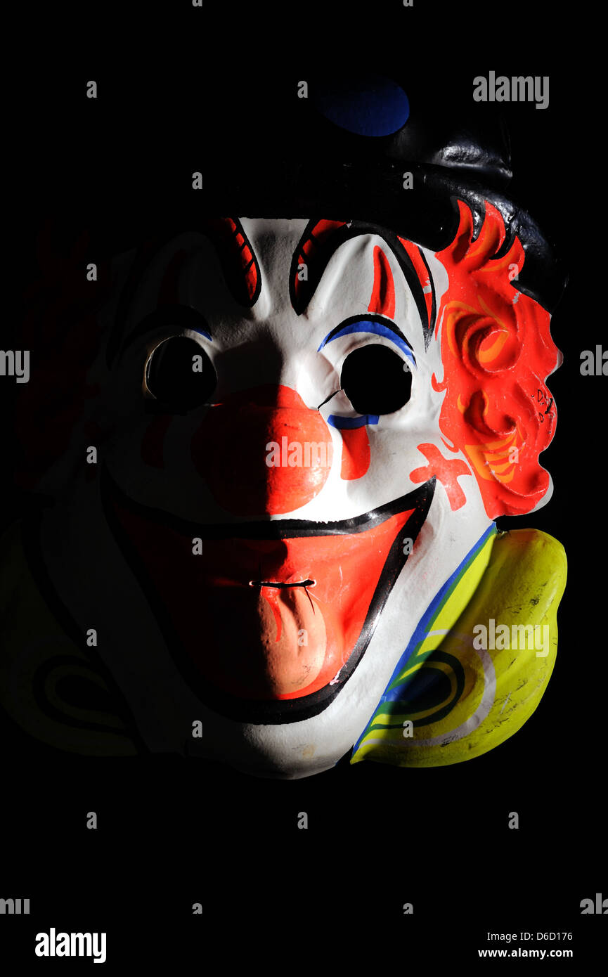 Maschera di clown nascondere qualcosa di minaccioso. Foto Stock