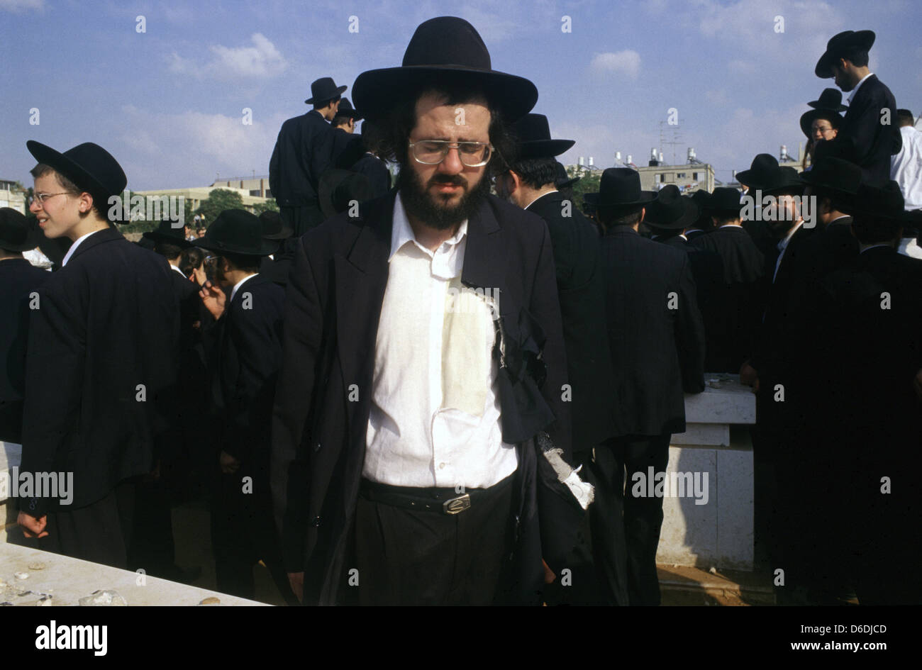 Ebreo ultra ortodosso con vestiti strappati come gesto di lutto ad un funerale Rabbi nella città di Bnei Brak o bene Beraq un centro del giudaismo Haredi in Israele Foto Stock