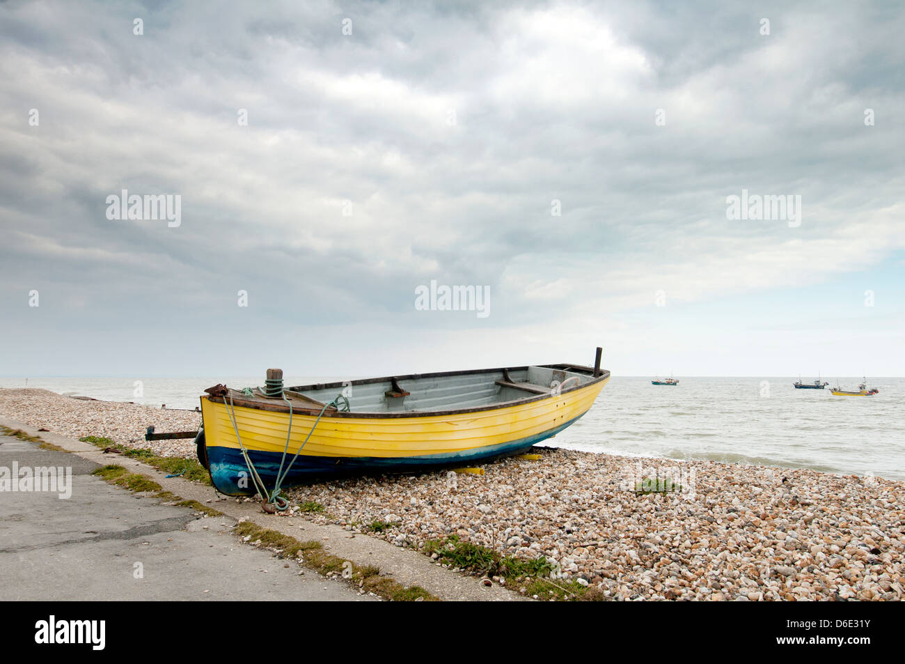 Giallo barca da pesca sulla riva a Selsey Bill Foto Stock