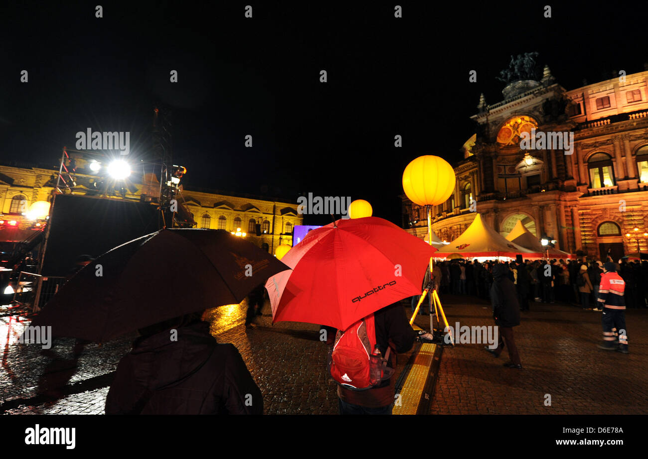Schaulustige haben am Freitag (20.01.2012) vor der Semperoper di Dresda wegen des schlechten Wetters Regenschirme aufgespannt. Foto: Thomas Eisenhuth dpa/LSN Foto Stock