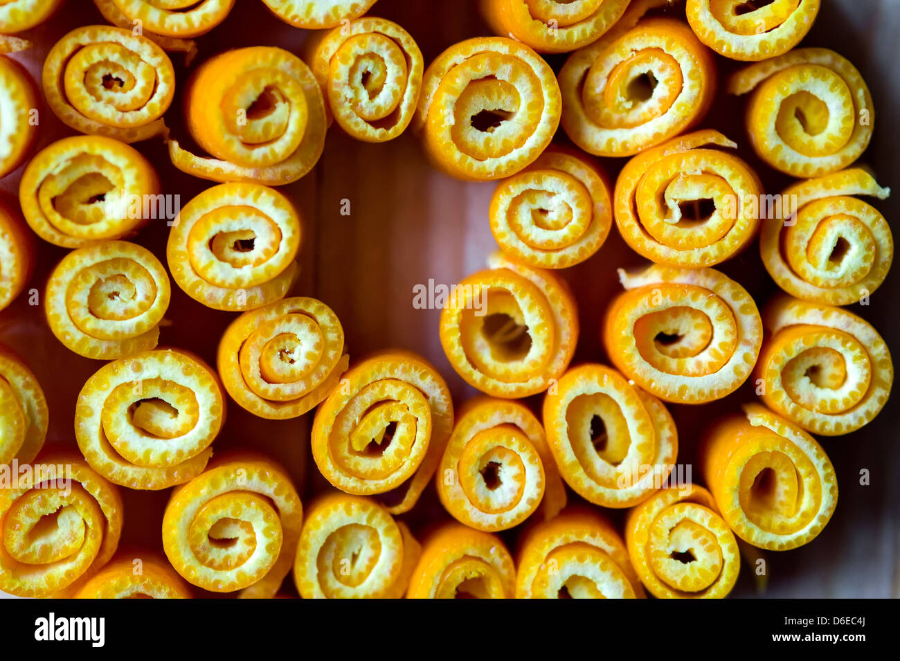 Macro di twisted bucce di arancia su uno sfondo di legno. Foto Stock