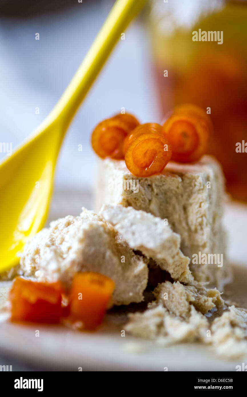 Il dolce halva ritorto con bucce di arancio e giallo cucchiaio su una piastra Foto Stock