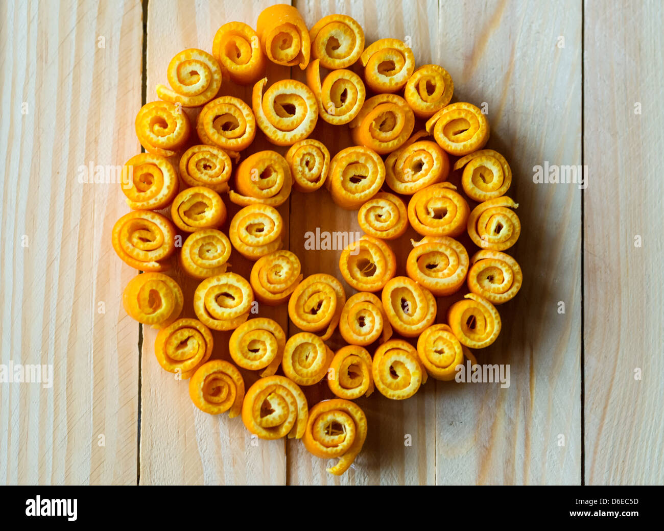 Macro di twisted bucce di arancia su uno sfondo di legno. Foto Stock
