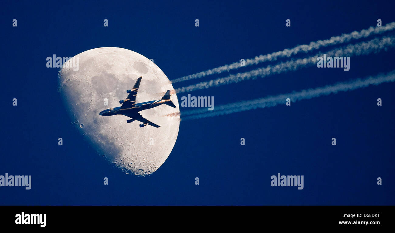 (Dpa-file) - Un file immagine datata 04 aprile 2009 mostra un aereo passato la luna in Sieversdorf, Germania. Il controverso le rotte aeree per il principale aeroporto BER sono presentati al pubblico il 26 gennaio 2012 a Berlino. Foto: Patrick Pleul Foto Stock