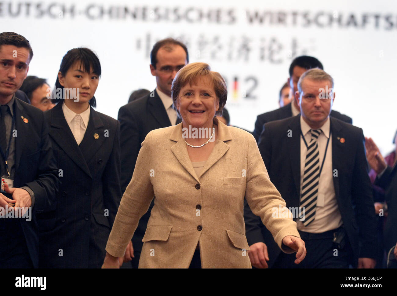 Il cancelliere tedesco Angela Merkel lascia il German-Chinese forum economico circondata da guardie del corpo a Guangzhou, Cina, 03 febbraio 2012. Merkel è in visita in Cina con una delegazione di alto livello dei politici e dei leader economici fino al 04 febbraio 2012. Foto: KAY NIETFELD Foto Stock