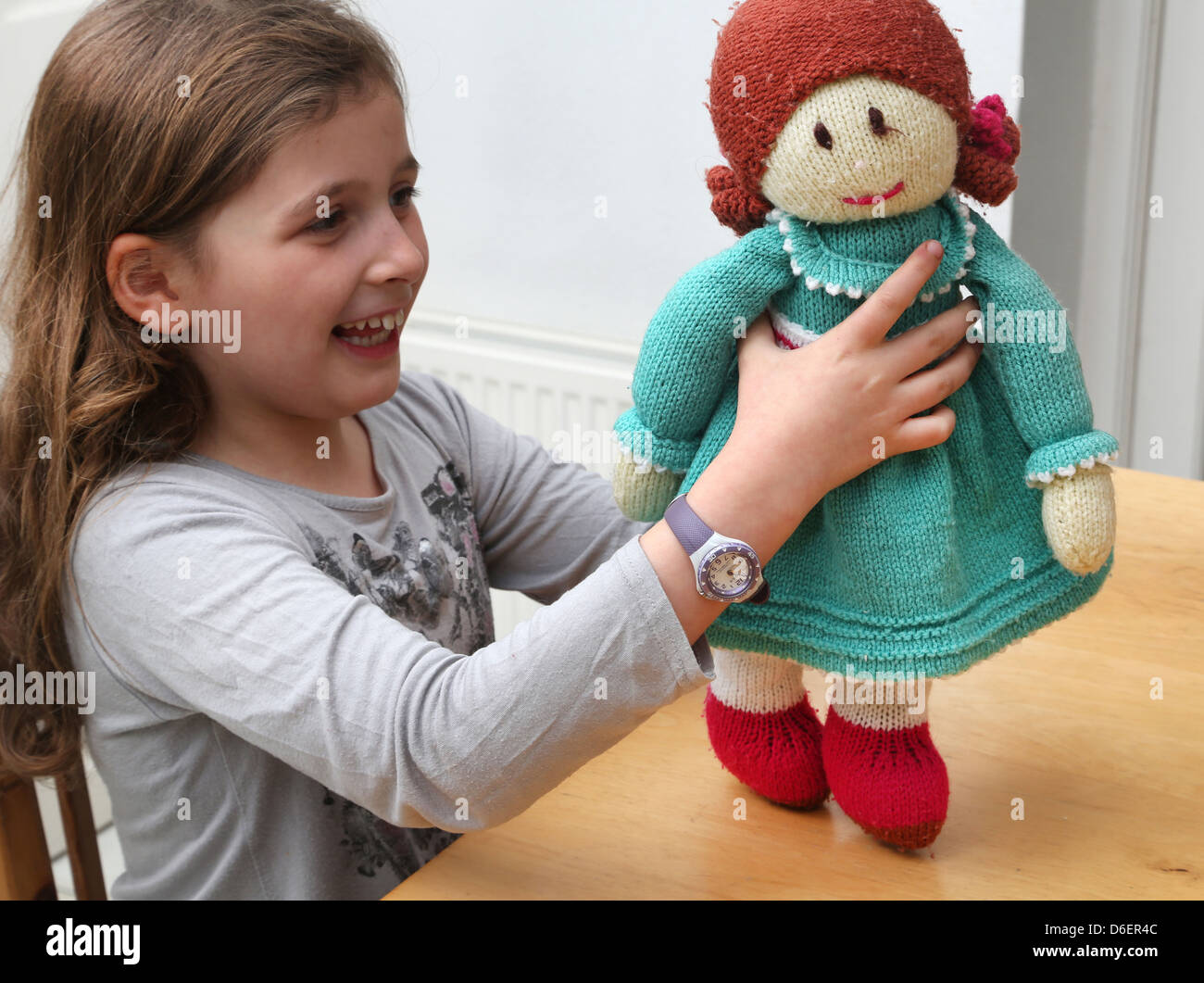 Ragazza giovane azienda Soffice bambola di Maglia Inghilterra Foto Stock