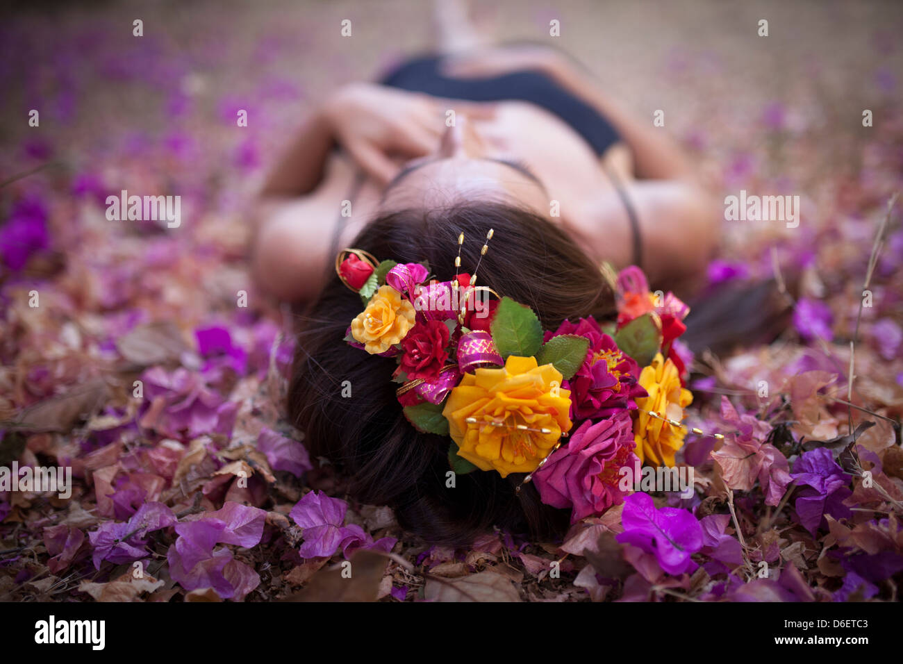 Una giovane donna giace in un letto di bugambilia in natura. Foto Stock