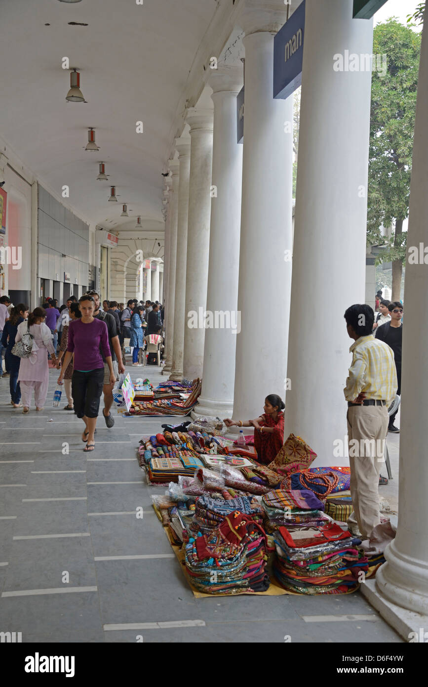 Gli amanti dello shopping sotto le alte arcate del British costruito (1931) complesso per lo shopping a Connaught Place in New Delhi, India Foto Stock