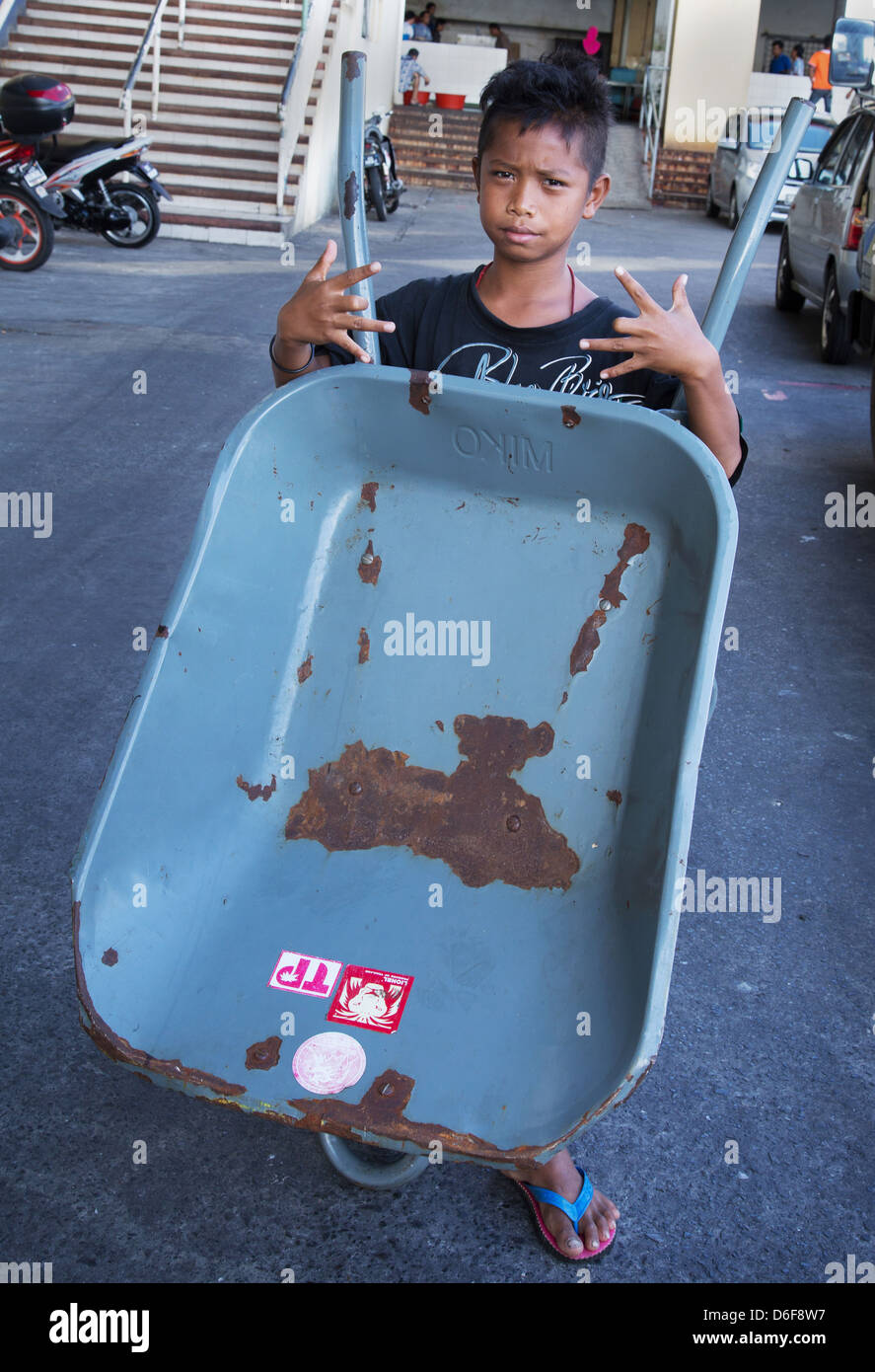 A Barrow Boy in posa per una fotografia al di fuori di un mercato in Sandakan sulla costa orientale di Sabah Borneo Foto Stock