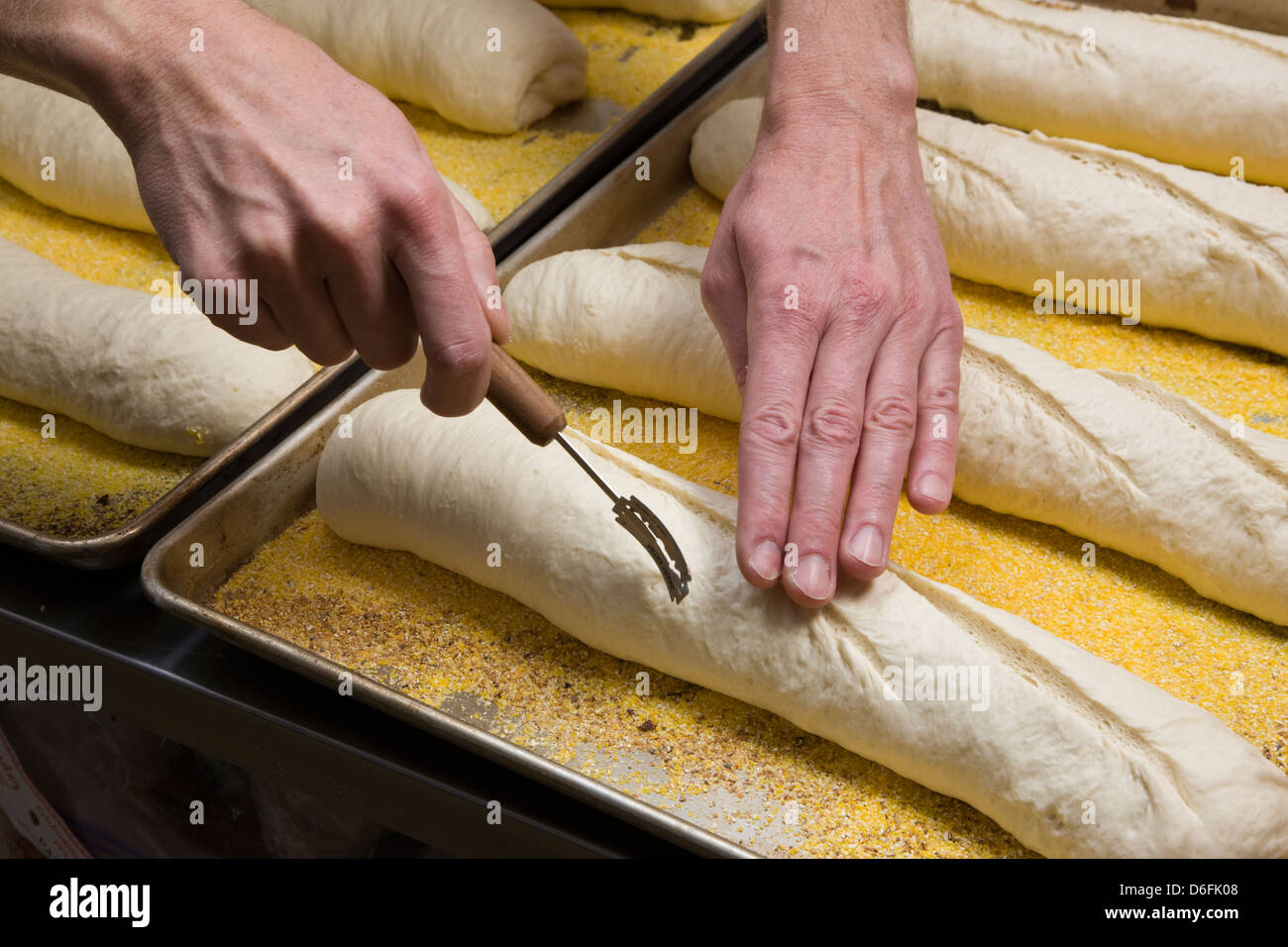 Cuoco professionista, preparare il pane fresco in un forno commerciale Foto Stock
