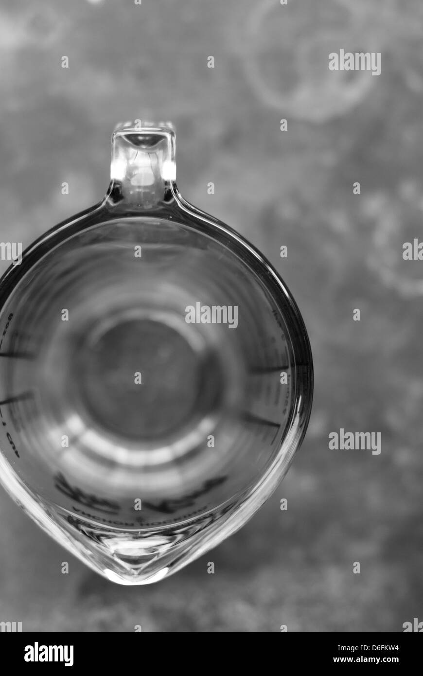 Vista dall'alto di un vetro antico liquido coppa di misurazione su un contatore Gray Foto Stock