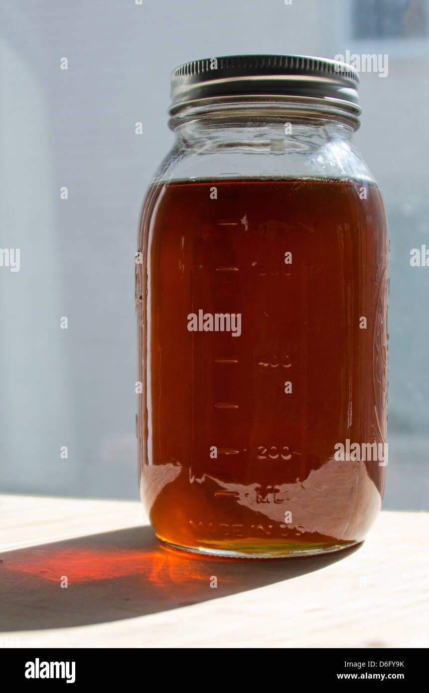 Un bicchiere di canning vaso pieno di fatti in casa di sciroppo di acero Foto Stock