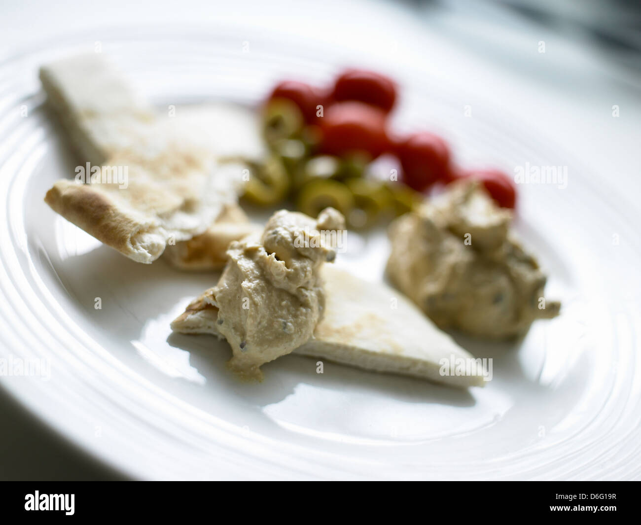 Humous con pane pitta, olive e pomodori Foto Stock