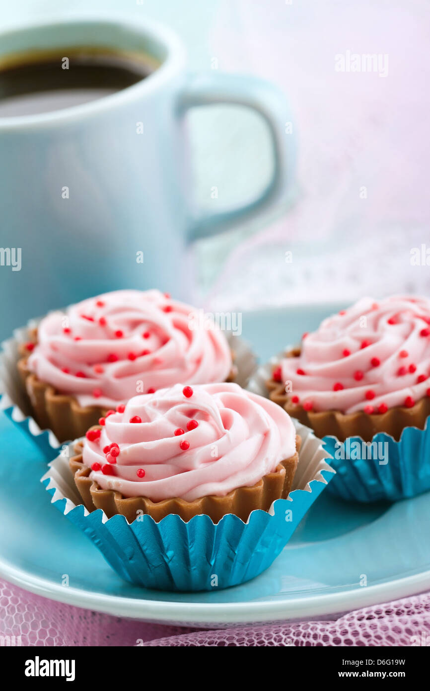 Assortimento di cupcake rosa praline di cioccolato con una tazza di caffè Foto Stock