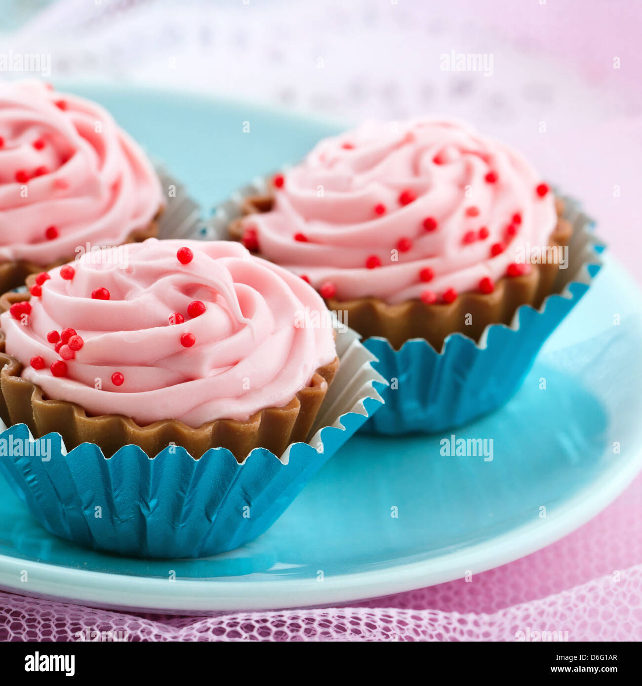 Primo piano della deliziosa rosa Bonbons di cioccolato su shabby chic color pastello sullo sfondo Foto Stock