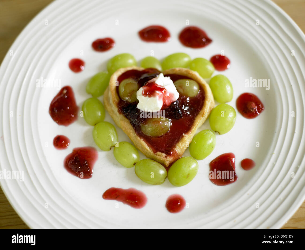 Pasta sfoglia con cuore plumb e uva - con ricetta / fase shot Foto Stock