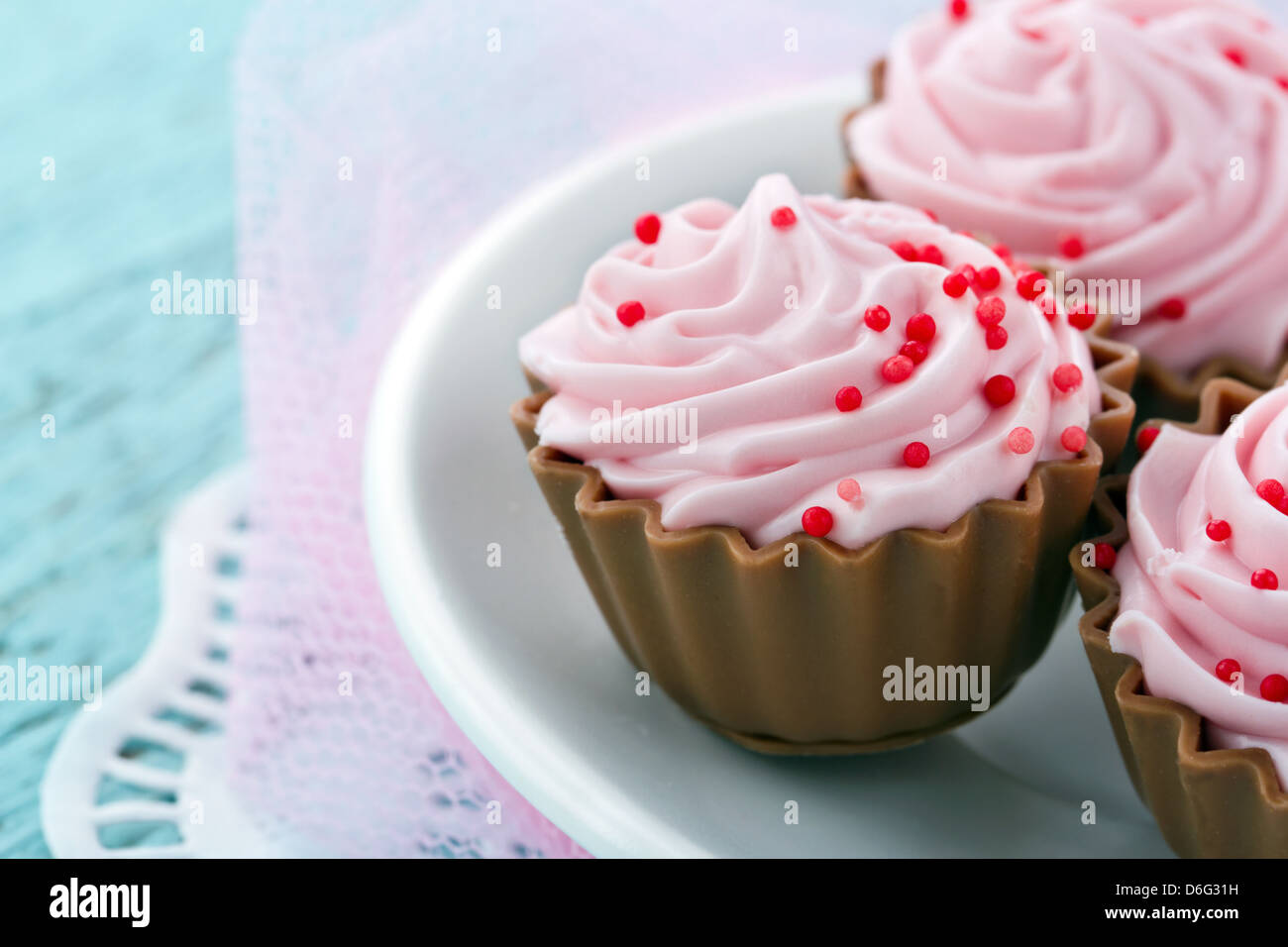 Rosa cupcake cioccolato praline su vintage sfondo pastello Foto Stock
