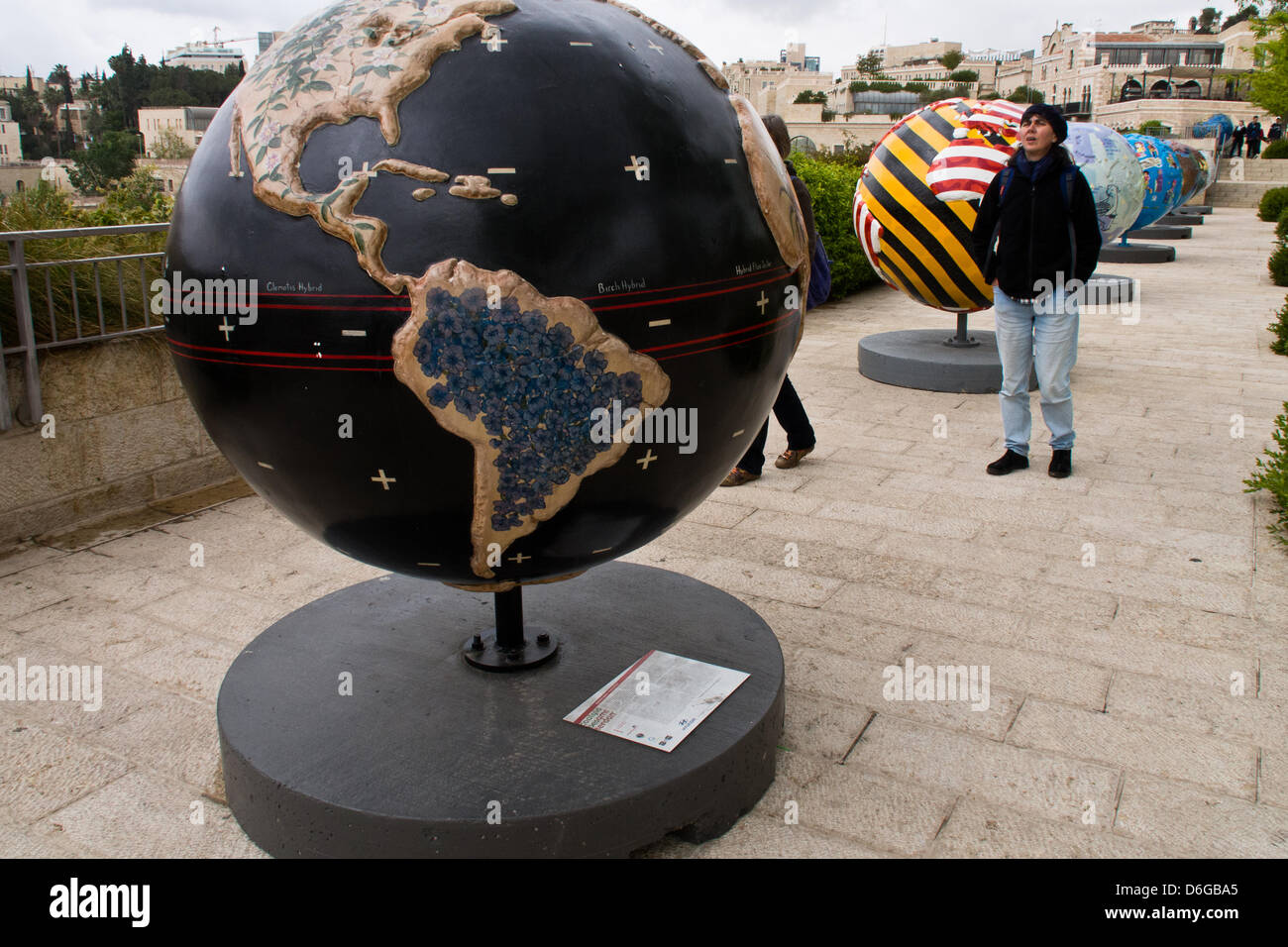 Gerusalemme, Israele. Il 18 aprile 2013. I turisti e la gente del luogo esaminare una mostra di diciotto Cool globi, ciascuno del peso di una tonnellata, sul display all'Alrov-Mamilla Esplanade vicino alla Porta di Jaffa, che mira a sensibilizzare il pubblico ai cambiamenti climatici e la chiamata per l'azione. Gerusalemme, Israele. 18-Aprile-2013. Raffreddare i globi: Hot idee per un pianeta dello scambiatore di calore è un pubblico mostra d'arte progettato per aumentare la consapevolezza delle soluzioni per il cambiamento climatico. Raffreddare i globi è stata iniziata nel 2005 e incorporato come un non-profit nel 2006. Raffreddare i globi premiered a Chicago nel 2007.Credit: Nir Alon/Alamy Live News Foto Stock