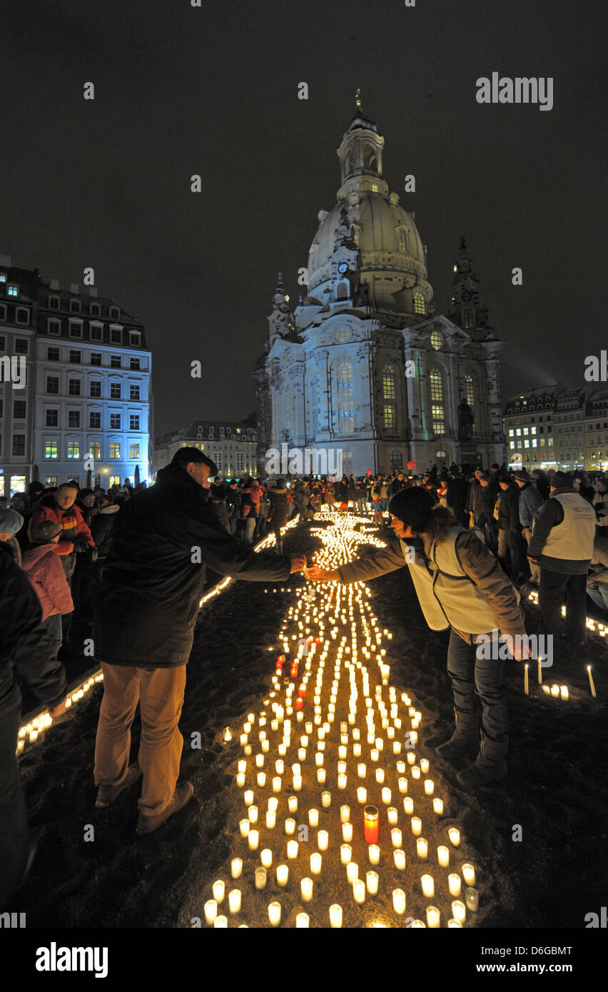 Persone accendono le candele di fronte la Frauenkirche di Dresda, in Germania, il 13 febbraio 2012. Le vittime dei bombardamenti di Dresda durante la II guerra mondiale sono ricordati il 13 febbraio 2012. Foto: Matthias Hiekel Foto Stock