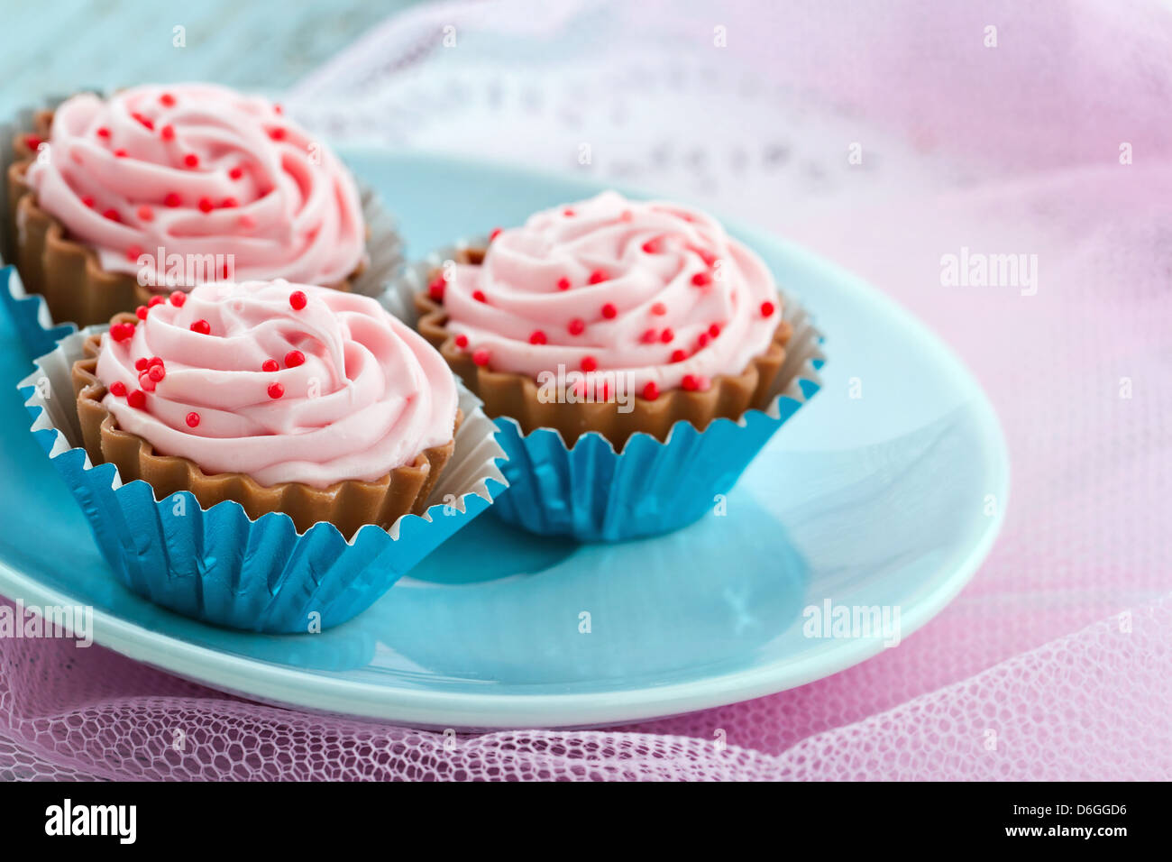 Piatto pieno di goloso cioccolato rosa dolciumi su shabby chic color pastello sullo sfondo Foto Stock