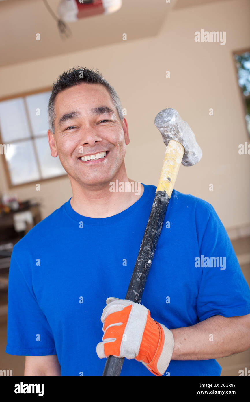 Uomo con mazza in garage Foto Stock