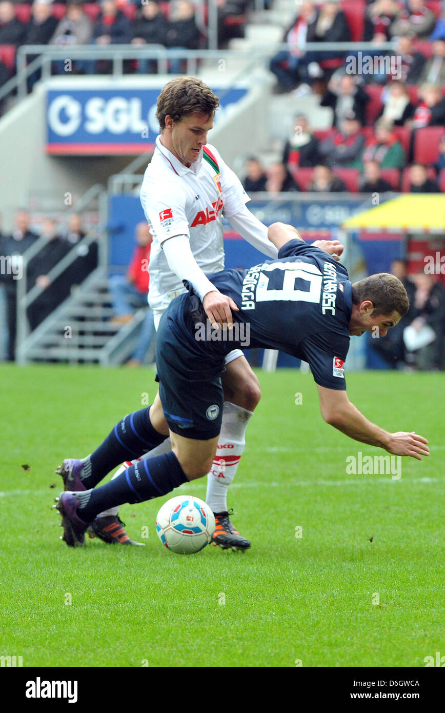 Augusta di Sebastian Langkamp (L) il sistema VIES per la palla con Berlino Lasogga Pierre-Michel durante la Bundesliga tedesca match tra FC Augsburg e Hertha BSC a SDL-Arena di Augsburg, Germania, 25 febbraio 2012. Foto: STEFAN PUCHNER (ATTENZIONE: embargo condizioni! Il DFL permette l'ulteriore utilizzazione delle immagini nella IPTV, servizi di telefonia mobile e altre nuove tecnologie solo n. Foto Stock