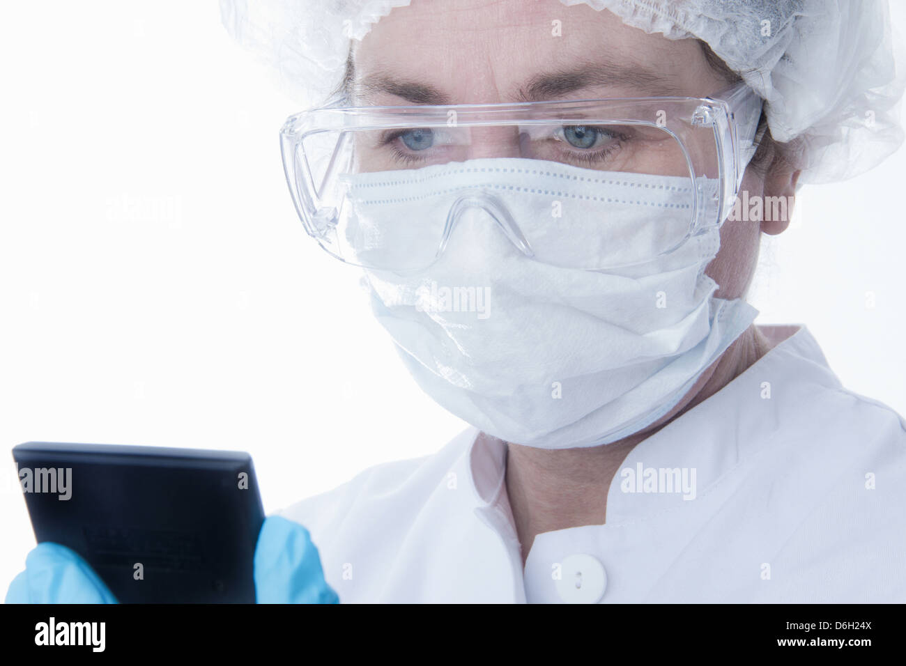 Dottore in maschera facciale utilizzando computer tablet Foto Stock
