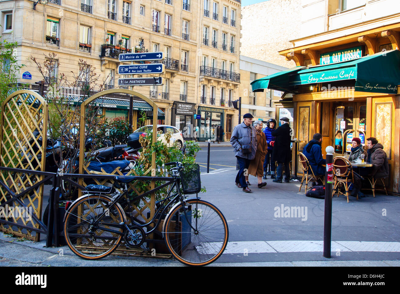 Scena di strada di Parigi, Francia - persone di passaggio da piccoli street café in cui altre persone a bere caffè durante una sessione di chat Foto Stock