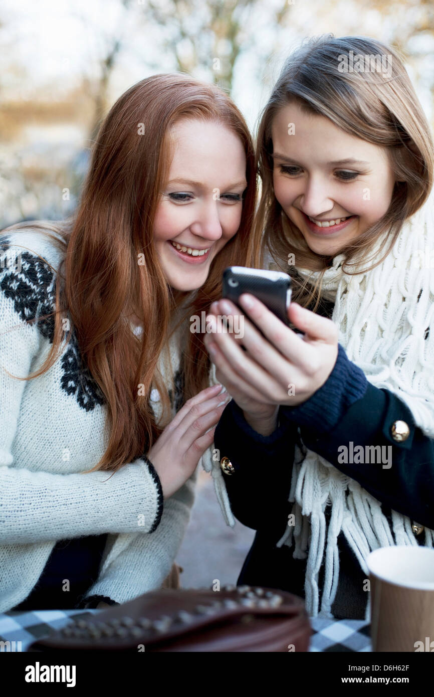 Le donne che utilizzano il telefono cellulare insieme Foto Stock