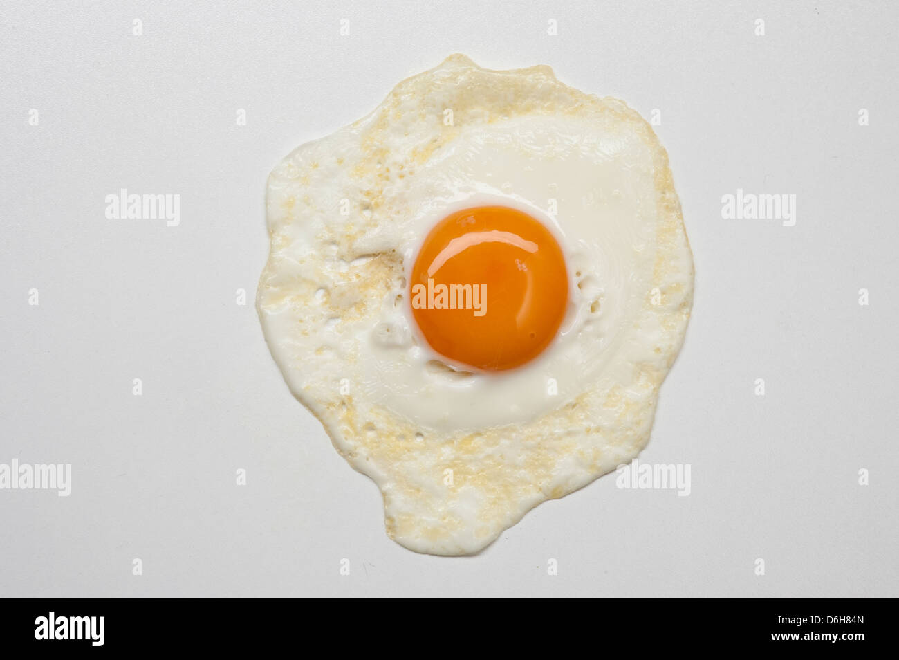 Uovo fritto su sfondo bianco Foto Stock