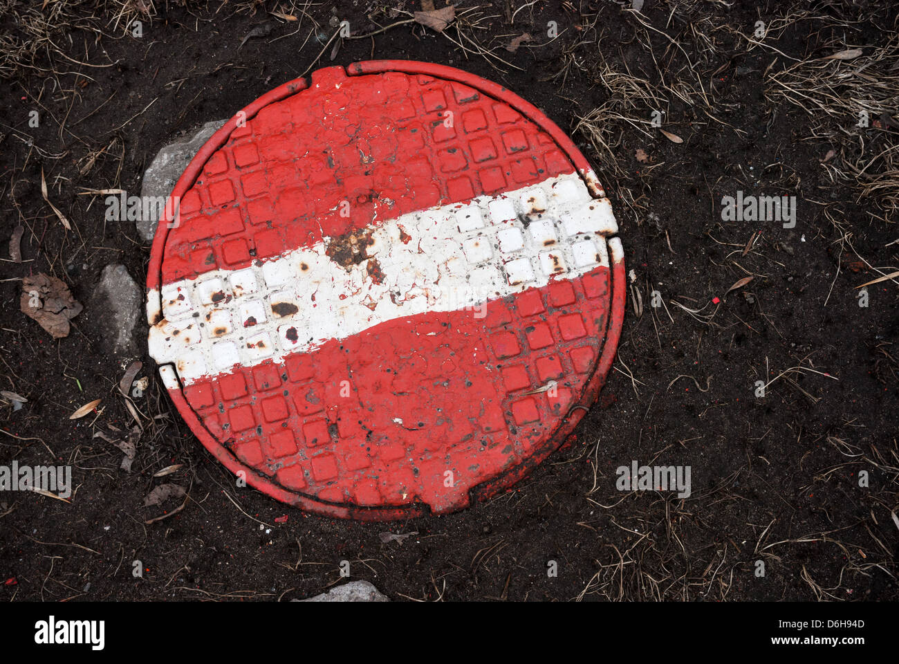 In tondo di acciaio tombino fognario con dipinti di rosso segno di stop su di esso Foto Stock