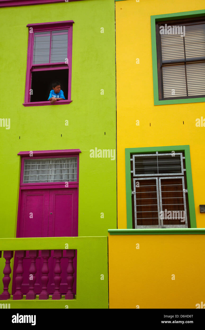 Ragazzo a guardare fuori dalla finestra di casa colorati, Bo-Kaap, Cape Town, Sud Africa Foto Stock