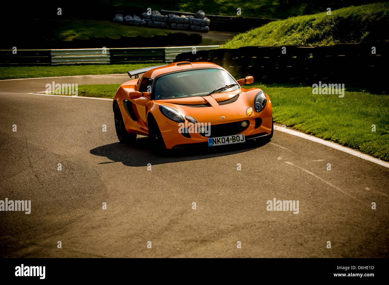 Orange Serie 2 Lotus Exige (girato da un angolo basso) in pista a Cadwell Park. Foto Stock