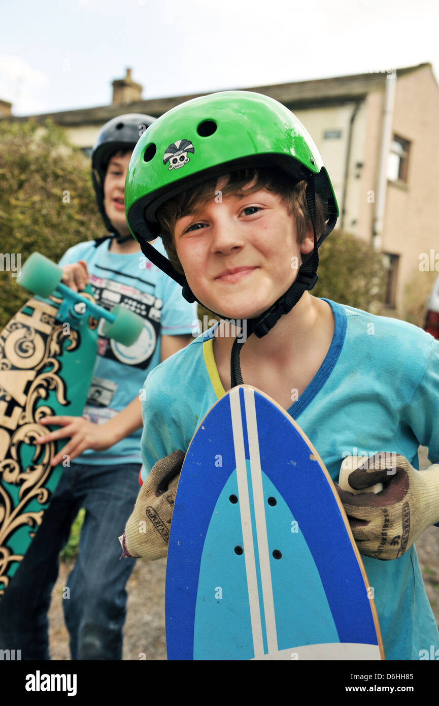 Due ragazzi con i loro skateboard e caschi modello rilasciato Foto Stock