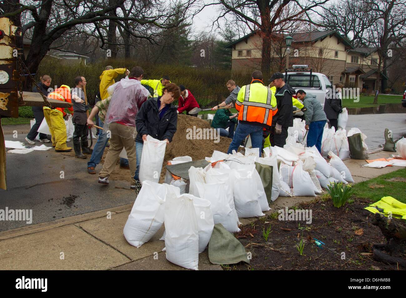 River Forest, Illinois, Stati Uniti d'America. Il 18 aprile 2013. Volontari riempire sacchi di sabbia sul fiume Oaks Drive adiacente al Des Plaines River. Il fiume è atteso a diluvio a livelli record a causa di piogge pesanti. Foto Stock