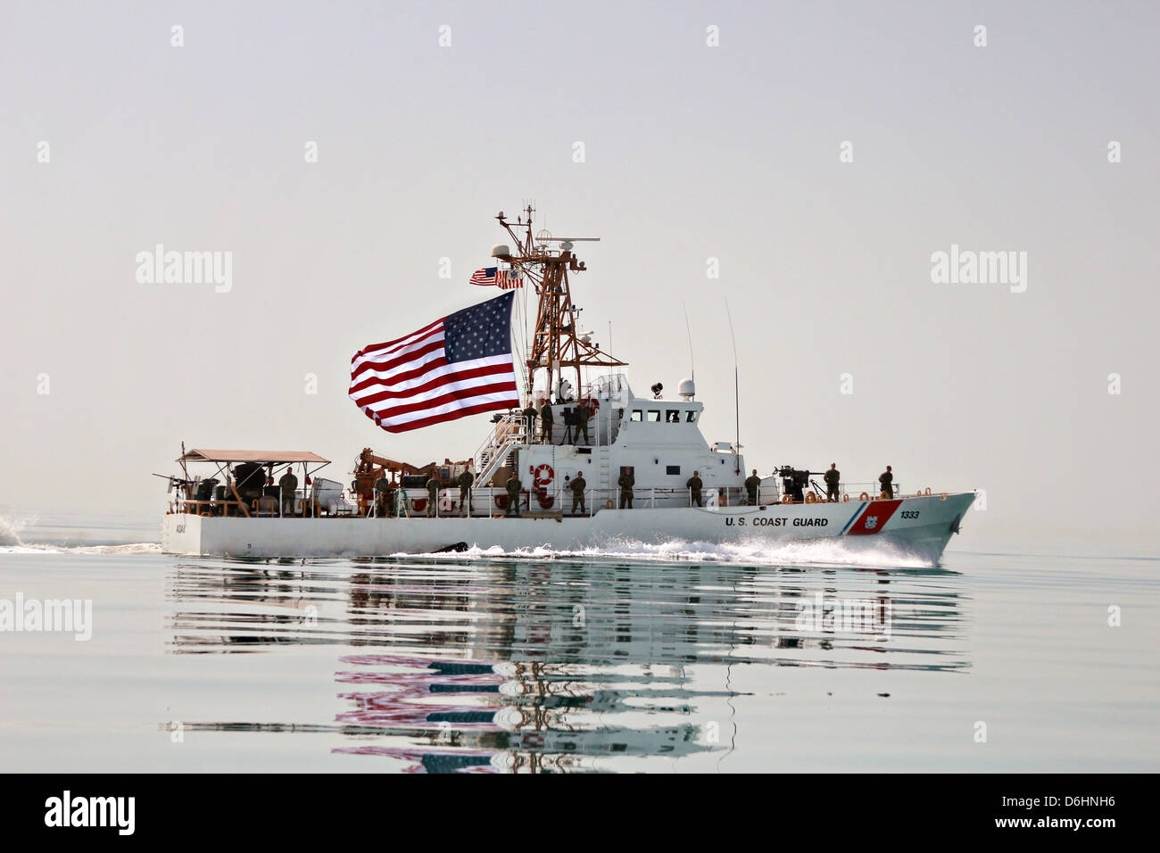 US Coast guardie a bordo della USCG taglierina Adak volare un jumbo noi bandiera durante le operazioni a sostegno della guerra in Afghanistan, 11 aprile 2013 nel Mare Arabico. Foto Stock