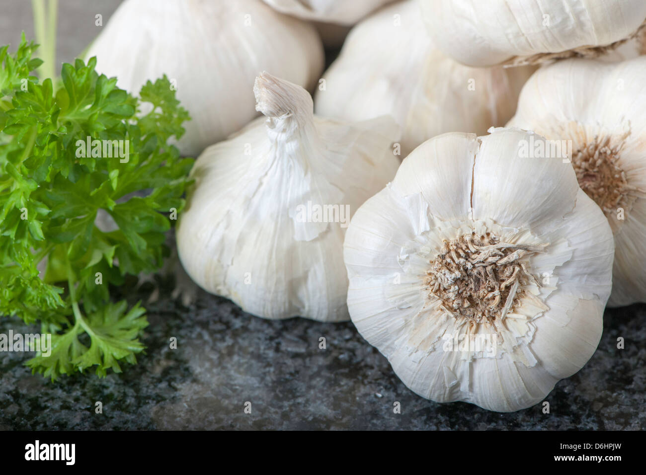 Aglio e prezzemolo sul piano di granito nero Foto Stock