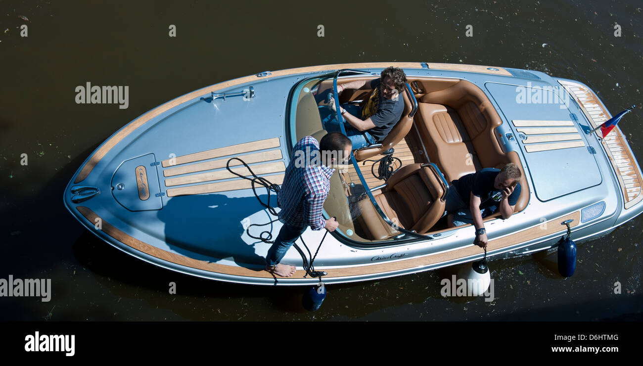Tre uomini in una barca sul fiume Moldava, Praga Foto Stock