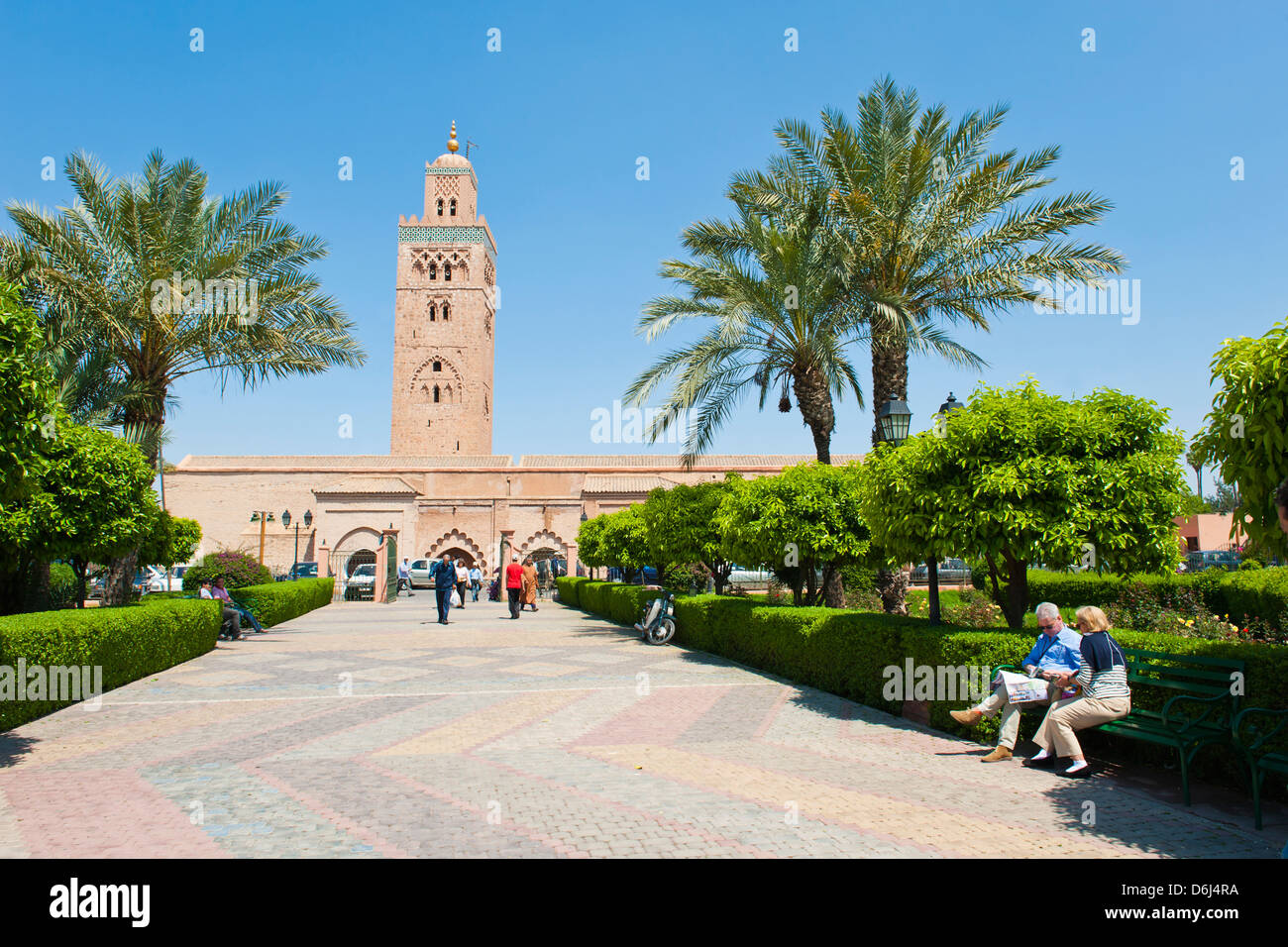 I turisti seduti nei giardini accanto alla Moschea di Koutoubia, Marrakech (Marrakech), Marocco, Africa Settentrionale, Africa Foto Stock